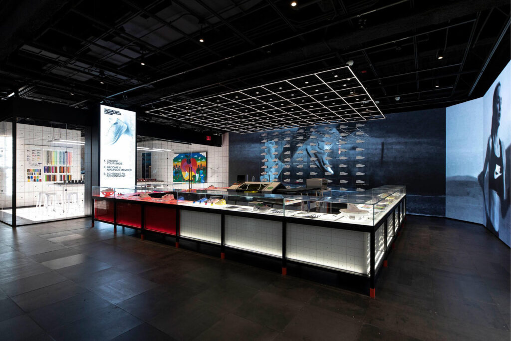 Interactive sneaker display zone at Nike House of Innovation showcasing customisation options, digital walls, and floating footwear installations.