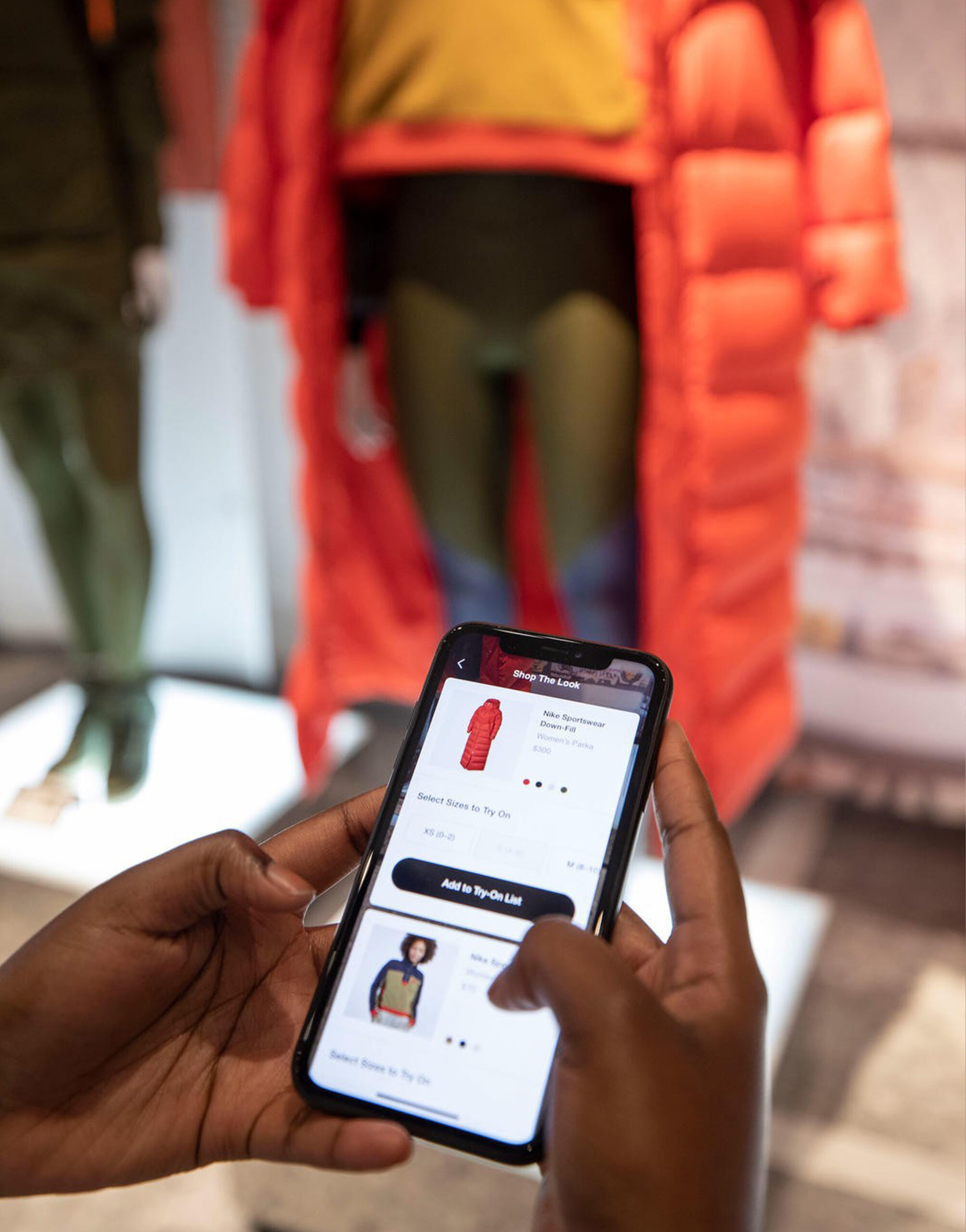 Customer using Nike app for in-store product selection and virtual try-on, integrating mobile technology with physical retail experience.