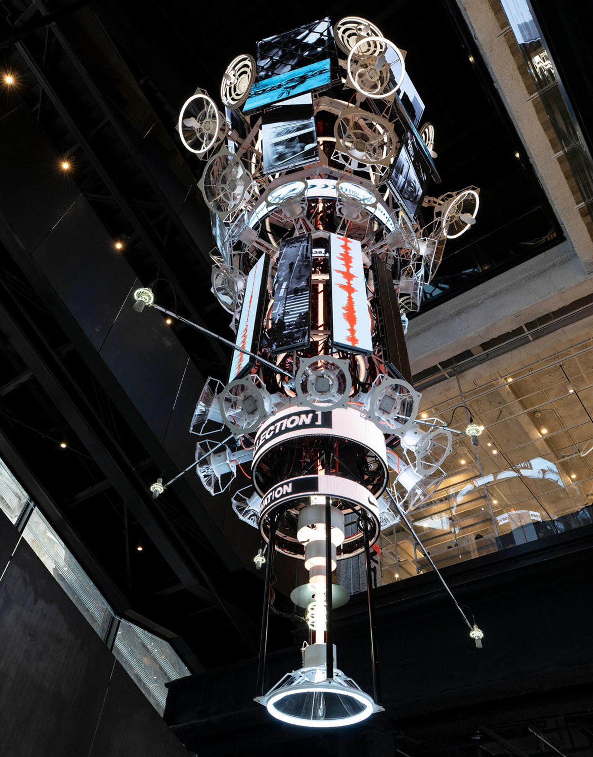Futuristic digital installation inside Nike House of Innovation featuring a towering kinetic sculpture with LED screens and sound-reactive visuals.