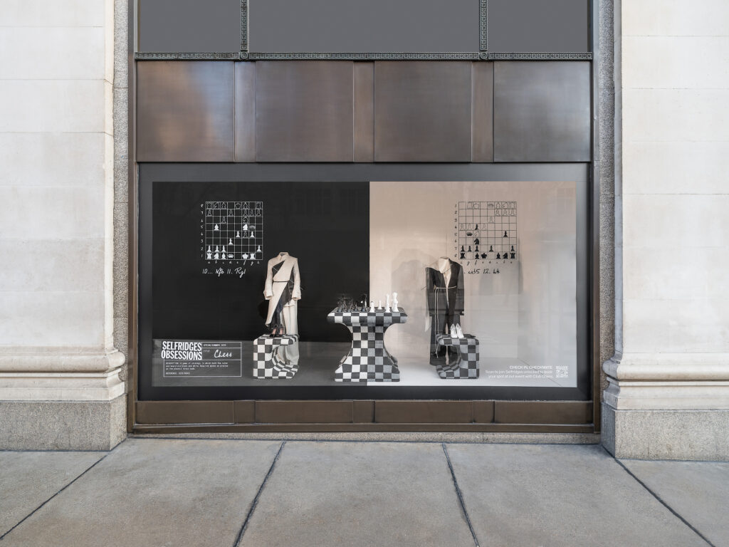 Selfridges Obsessions window display themed around chess, featuring monochrome styling, fashion pieces, and chessboard motifs.