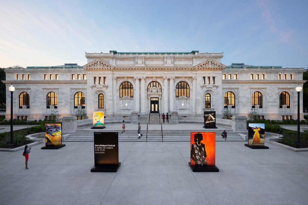 The Apple Carnegie Library store at Mount Vernon Square, Washington D.C., featuring neoclassical architecture with outdoor art displays and evening lighting.