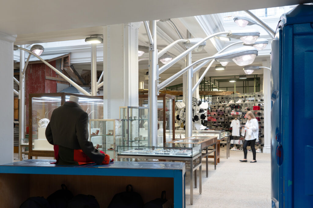Interior of Dover Street Market showcasing eclectic displays, industrial architecture, and avant-garde fashion pieces within a creative retail space.