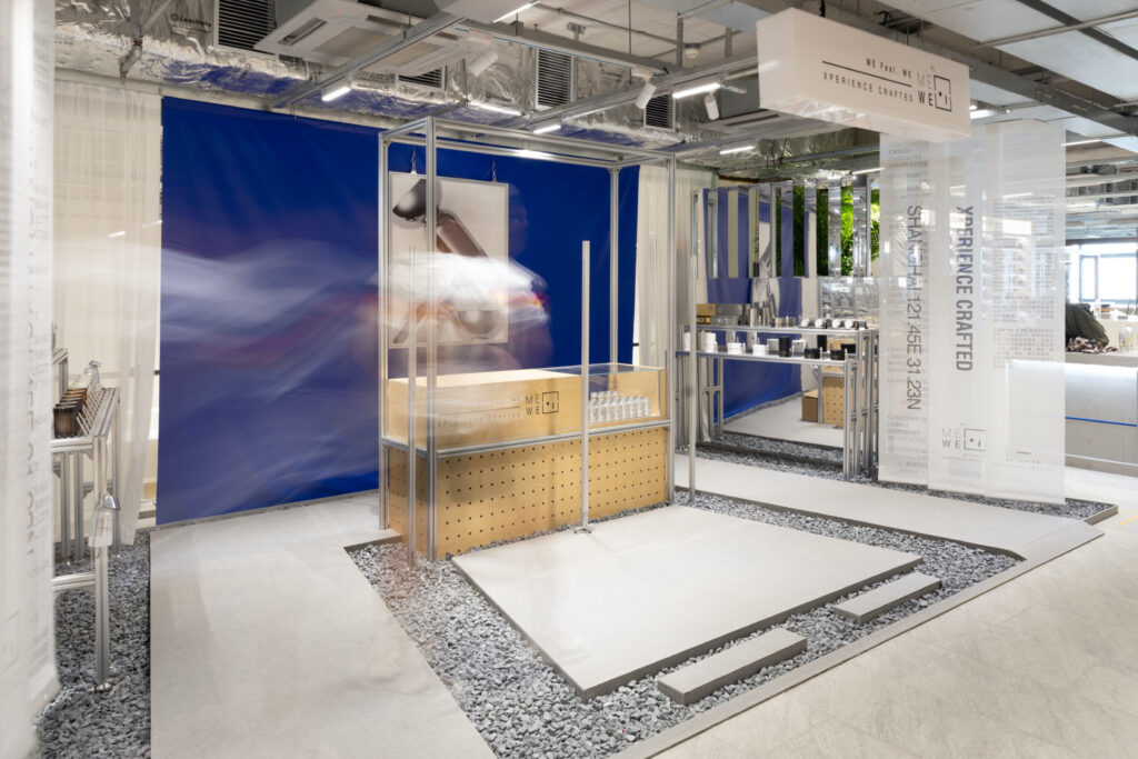 Minimal industrial interior with exposed ceilings, modular furniture, and clean lines in a collaborative retail and creative workspace.