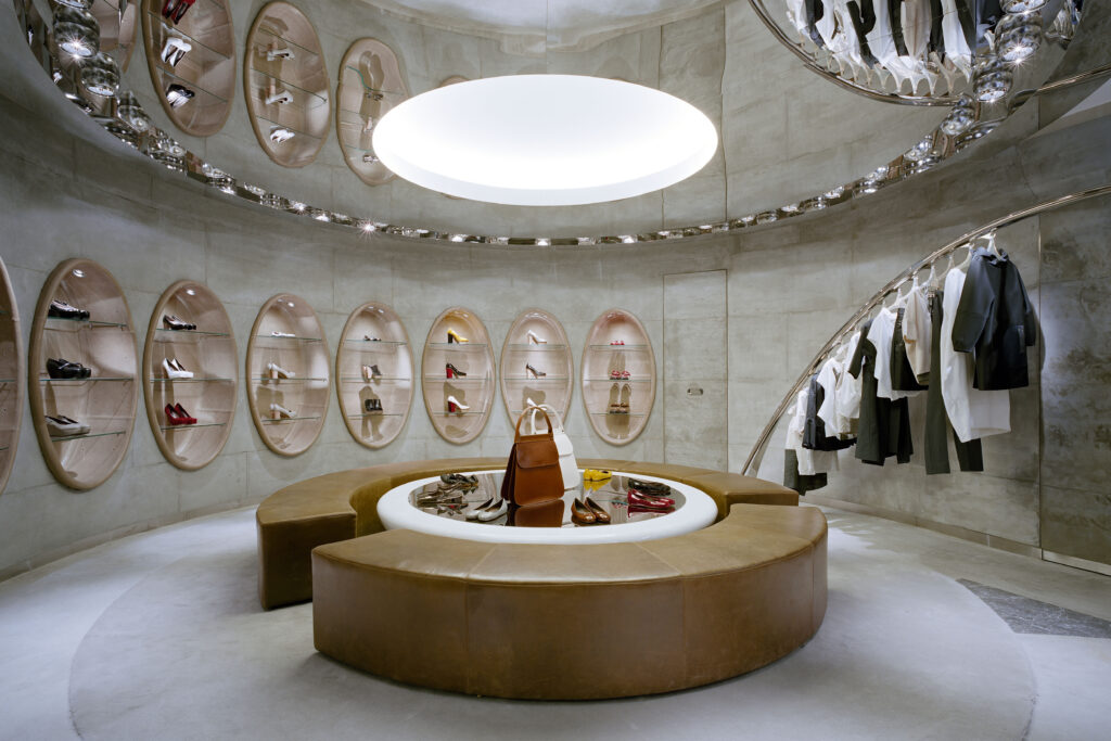 Marni Monobrand store in Aoyama, Tokyo showcasing illuminated niche displays for handbags, shoes, and accessories with a curved layout.