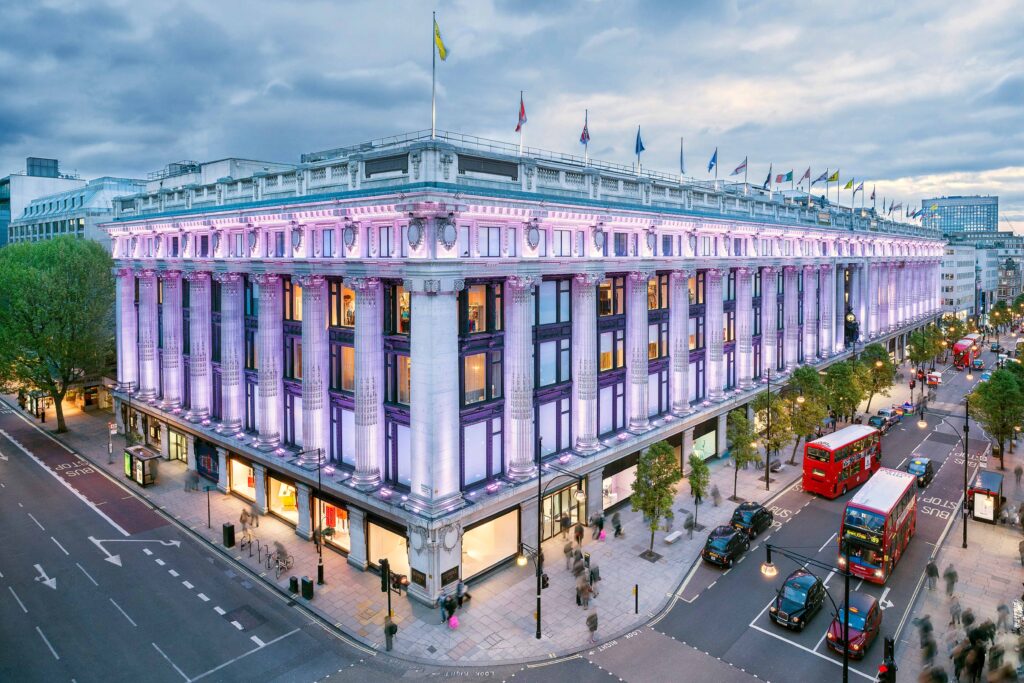 Selfridges on Oxford Street, London, illuminated with soft pastel lighting, reflecting timeless retail design principles in modern luxury retail.