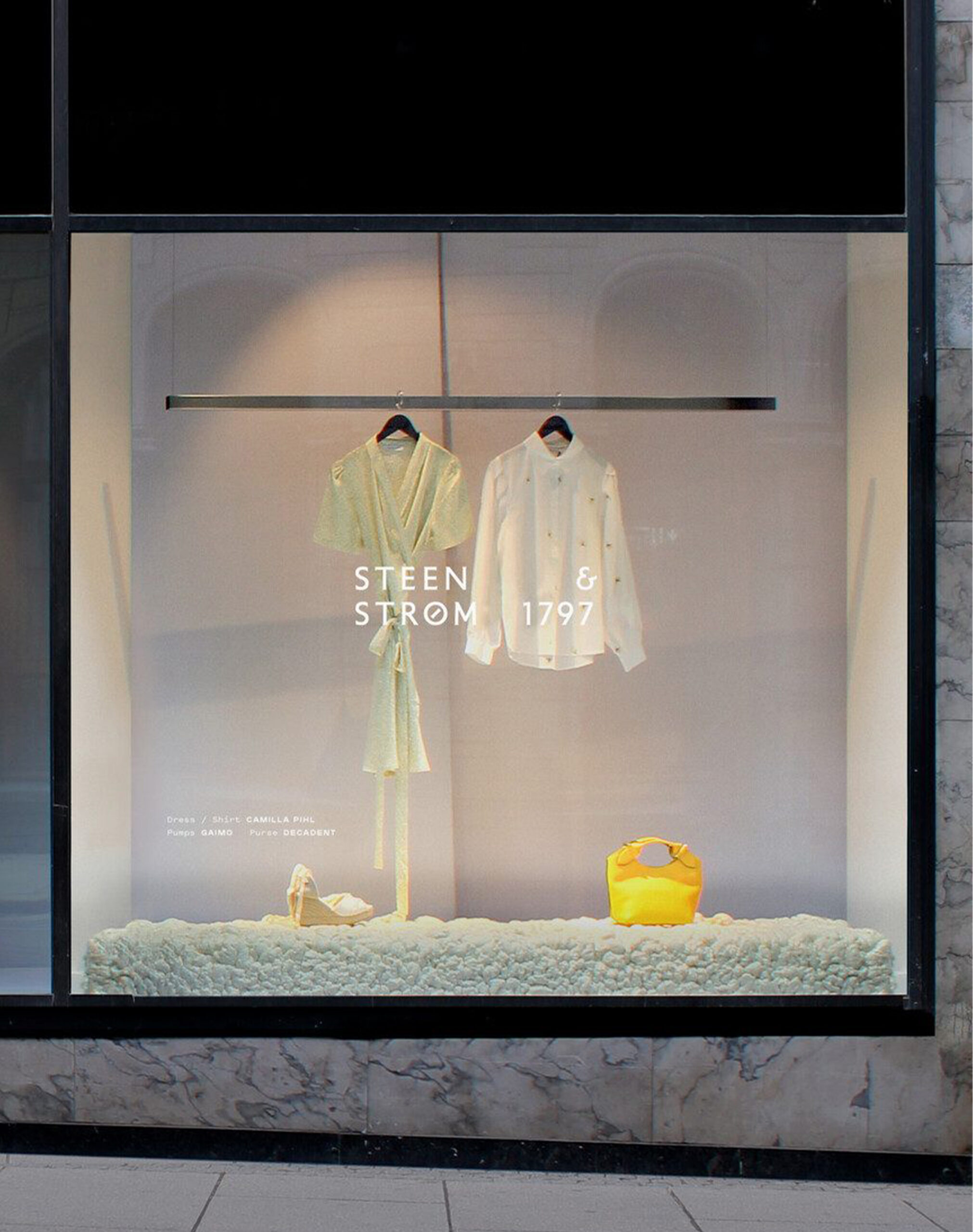 Minimalist window display at Steen & Strøm featuring curated fashion pieces and elegant styling — reflecting timeless retail design principles in visual merchandising.