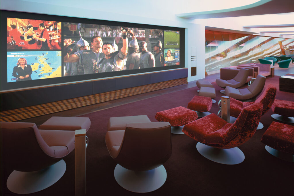 Interior views of the Virgin Atlantic Heathrow Clubhouse in London, designed with a fluid, futuristic aesthetic. The space features organic curves, sculptural ceilings with ambient lighting, and luxurious materials such as wood, leather, and glass. Various zones include a sunken lounge, cocktail bar, restaurant seating with olive trees, and relaxation areas with Eames chairs and large projection screens.