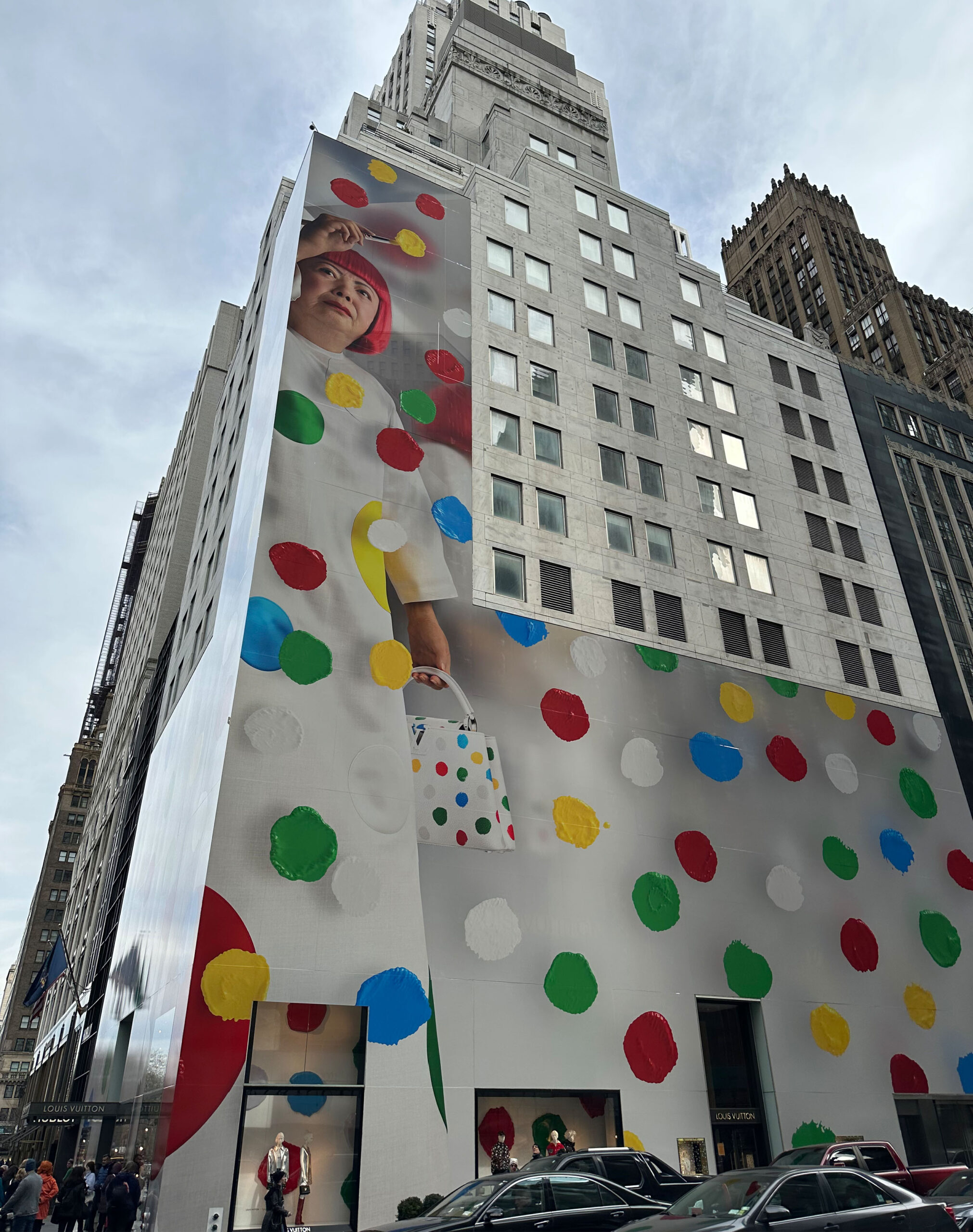 Louis Vuitton New York store wrapped in Yayoi Kusama’s signature polka-dot design, with a large-scale portrait of the artist on the building façade.