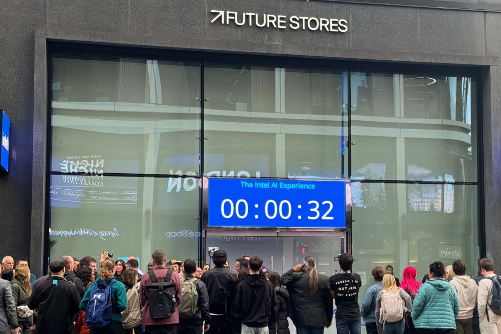 Crowd gathered outside Future Stores for the Intel AI Experience event, featuring a large digital countdown screen on the store’s modern glass façade.